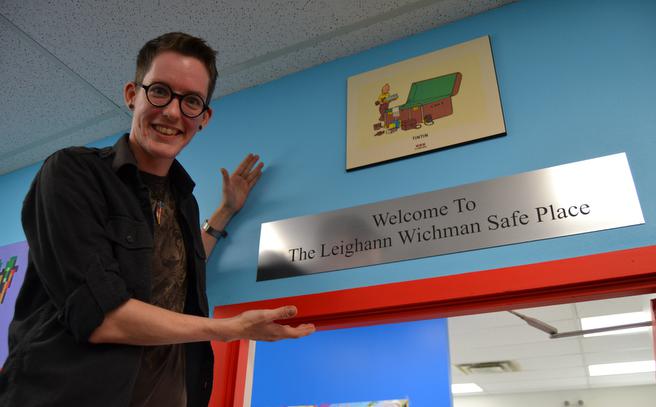 Jay Aaron Roy, owner and operator of Cape & Cowl Comics, proudly showcases the new plaque presented to the store on behalf of TD Canada, which officially names the store’s LGBTQ safe space after Leighann Wichman, Roy’s friend and mentor, who passed away last year. (Chris Muise)